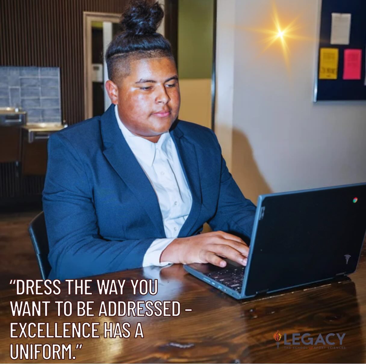 Legacy student wearing a formal uniform while working on a laptop
